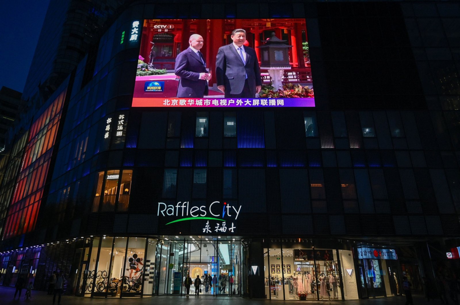 A large screen shows news coverage of Chinese President Xi Jinping (R) meeting German Chancellor Olaf Scholz, Beijing, China, April 16, 2024. (AFP Photo)