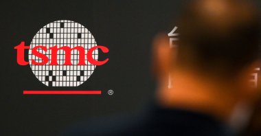 A man walks past a logo of the Taiwan Semiconductor Manufacturing Company (TSMC) during a shareholders' meeting in Hsinchu, June 6, 2023. (AFP Photo)