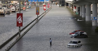 A person stands surrounded by flood water caused by heavy rains, Dubai, United Arab Emirates (UAE), April 17, 2024. (Reuters Photo)