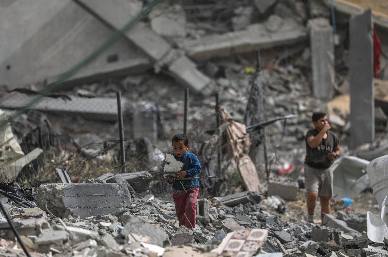 Palestinian children walk among the rubble after returning to Al Nusairat refugee camp following the Israeli army&#039;s withdrawal from the area, southern Gaza Strip, April 18, 2024. (EPA Photo)