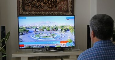A man watches an Iranian media announcement of an explosion in the region of Isfahan province, which hosts the Iranian Air Force Base, Iran, April 19, 2024. (AA Photo)