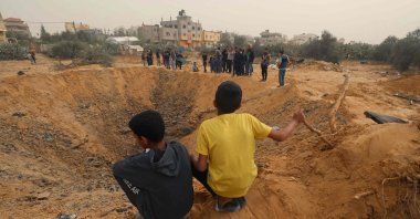 Two Palestinian boys look a huge crater following overnight Israeli bombardment in Rafah in the southern Gaza Strip, Palestine, April 18, 2024. (AFP Photo)