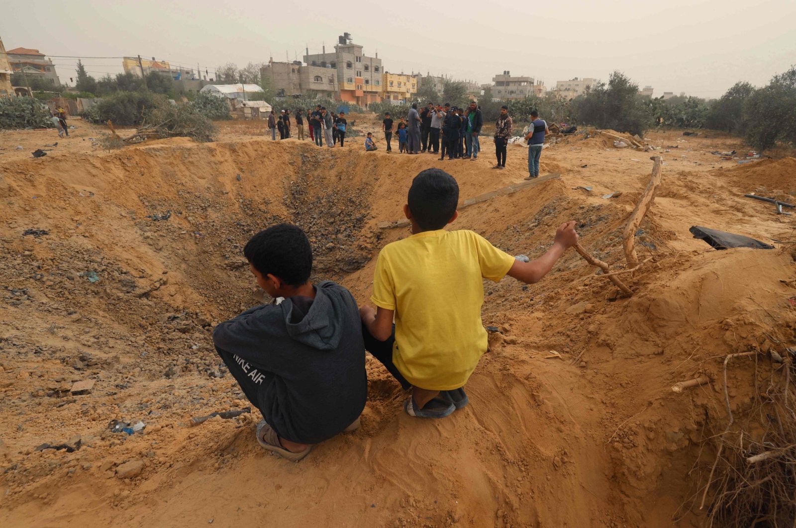 Two Palestinian boys look a huge crater following overnight Israeli bombardment in Rafah in the southern Gaza Strip, Palestine, April 18, 2024. (AFP Photo)