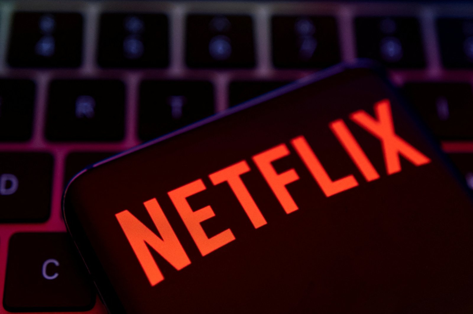 A smartphone with a Netflix logo is placed on a keyboard in this illustration taken on April 19, 2022. (Reuters Photo)