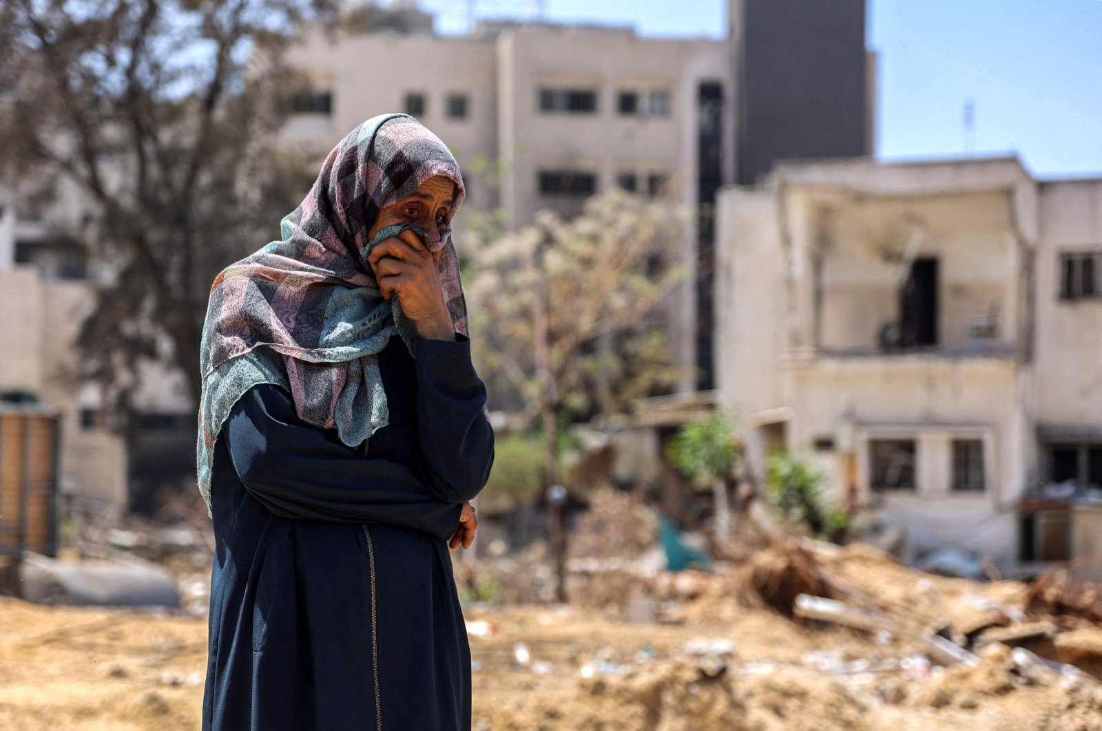 A woman reacts as she watches Palestinian forensic experts and others search for bodies of dead people in the vicinity of Al-Shifa Hospital in Gaza City on April 17, 2024. (AFP Photo)