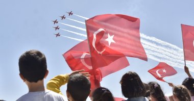Children waving Turkish flags are watching the air show of the Turkish Stars jet aerobatics team, organized as part of National Sovereignty and Children’s Day celebrations, Konya, central Türkiye, April 21, 2024. (DHA Photo)