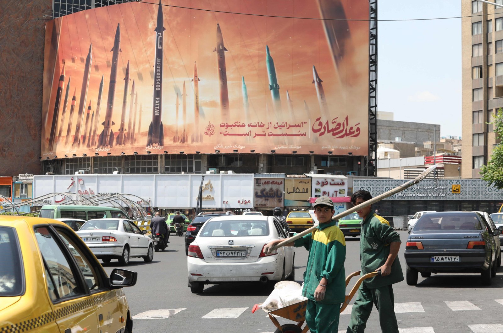 Motorists drive their vehicles past a billboard depicting Iranian missiles in Tehran, Iran, April 20, 2024. (AFP Photo)