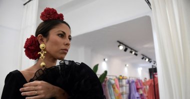 Customer Virginia Cuaresma tries on a flamenco dress at Luis Fernandez&#039;s workshop in Seville, Spain, April 8, 2024. (AFP Photo)