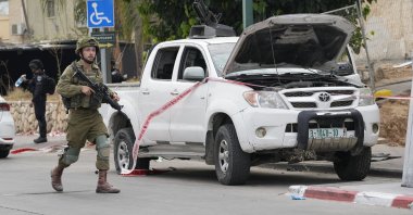 Israeli soldier walks by a pickup truck used by Palestinian resistance members in Sderot, Israel, Oct. 7, 2023. (AP Photo)