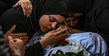 A woman mourns over the body of a man killed in an Israeli raid in the Nur Shams camp for Palestinian refugees in the occupied West Bank, April 21, 2024. (AFP Photo)