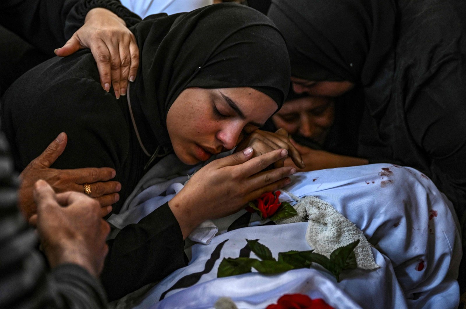 A woman mourns over the body of a man killed in an Israeli raid in the Nur Shams camp for Palestinian refugees in the occupied West Bank, April 21, 2024. (AFP Photo)