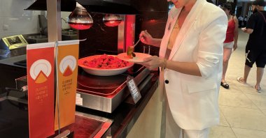 A guest selects food near an orange flag, awarded to hotels in Türkiye to support zero waste and food waste prevention efforts, April 22, 2024. (AA Photo)