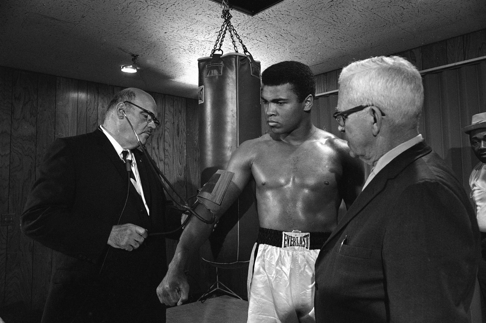 Dr. Leo Lemieux checks the blood pressure of heavyweight champion Cassius Clay, (C) as Maine Boxing Commission member Duncan MacDonald, (R), looks on, Maine, U.S., May 18, 1965. (AP Photo)