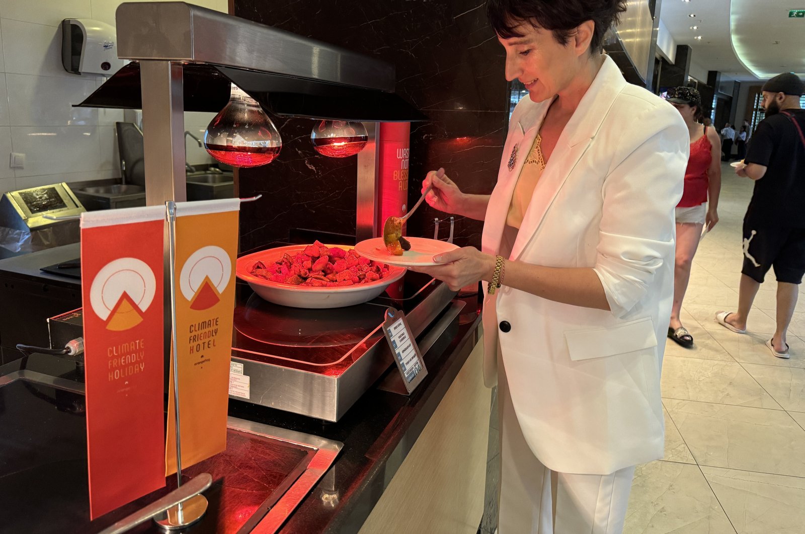 A guest selects food near an orange flag, awarded to hotels in Türkiye to support zero waste and food waste prevention efforts, April 22, 2024. (AA Photo)