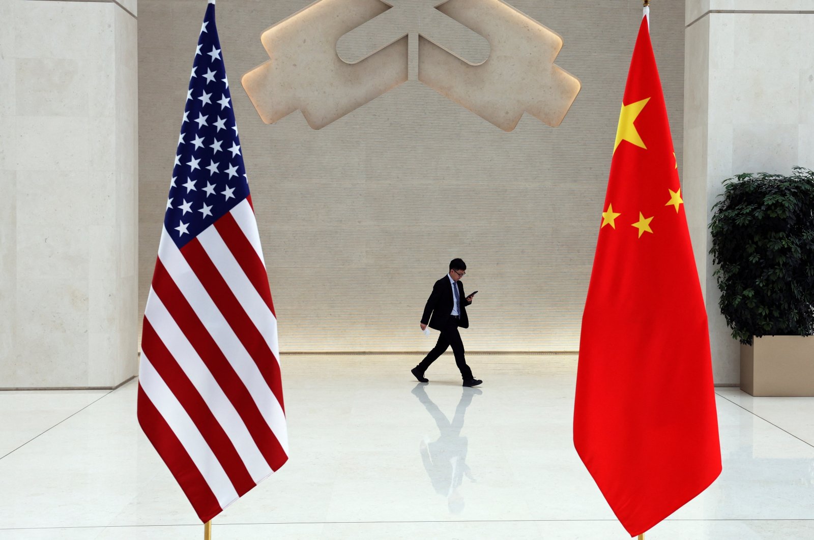A man walks past U.S. and Chinese flags on the day of a meeting between U.S. Treasury Secretary Janet Yellen and People&#039;s Bank of China (PBOC) Governor Pan Gongsheng, Beijing, China, April 8, 2024. (Reuters Photo)