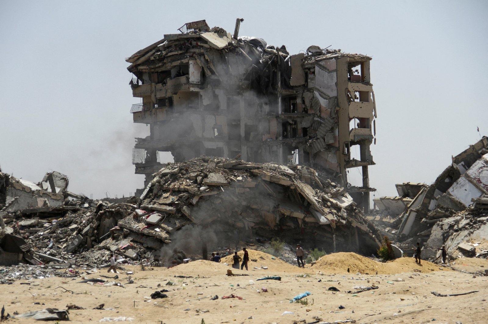 Palestinians walk past the rubble of residential buildings destroyed by Israeli strikes, northern Gaza Strip, Palestine, April 22, 2024. (Reuters Photo)