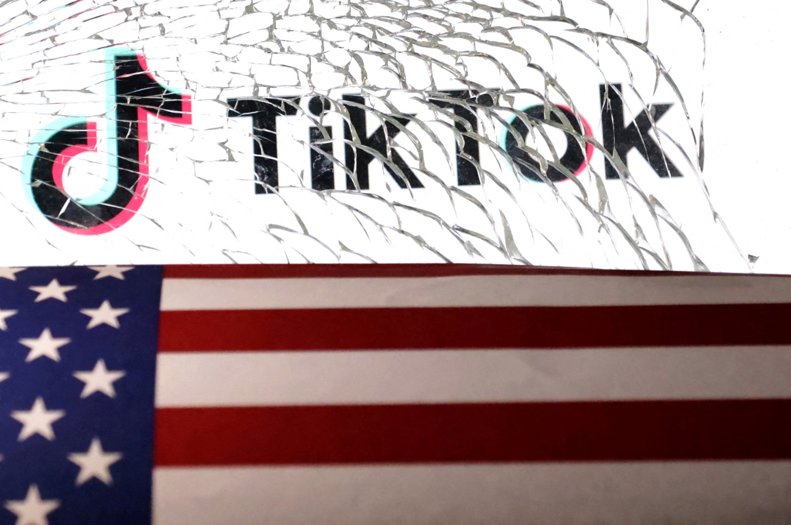 The U.S. flag and TikTok logo are seen through broken glass in this illustration taken March 20, 2024. (Reuters Photo)