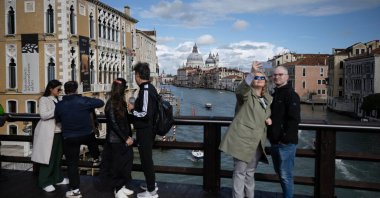 Tourists take selfies with the Grand Canal in the background on the "Ponte dell’Accademia" in Venice, Italy, April 24, 2024. (AFP Photo)