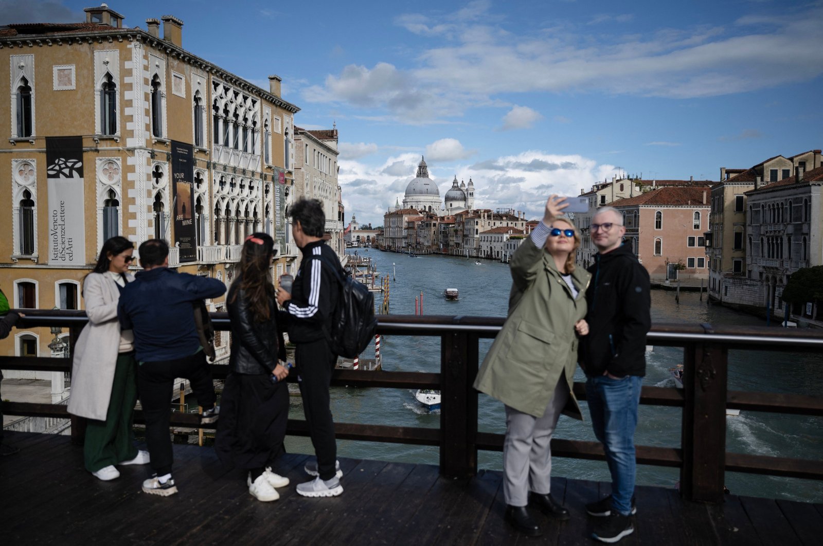 Tourists take selfies with the Grand Canal in the background on the &quot;Ponte dell’Accademia&quot; in Venice, Italy, April 24, 2024. (AFP Photo)