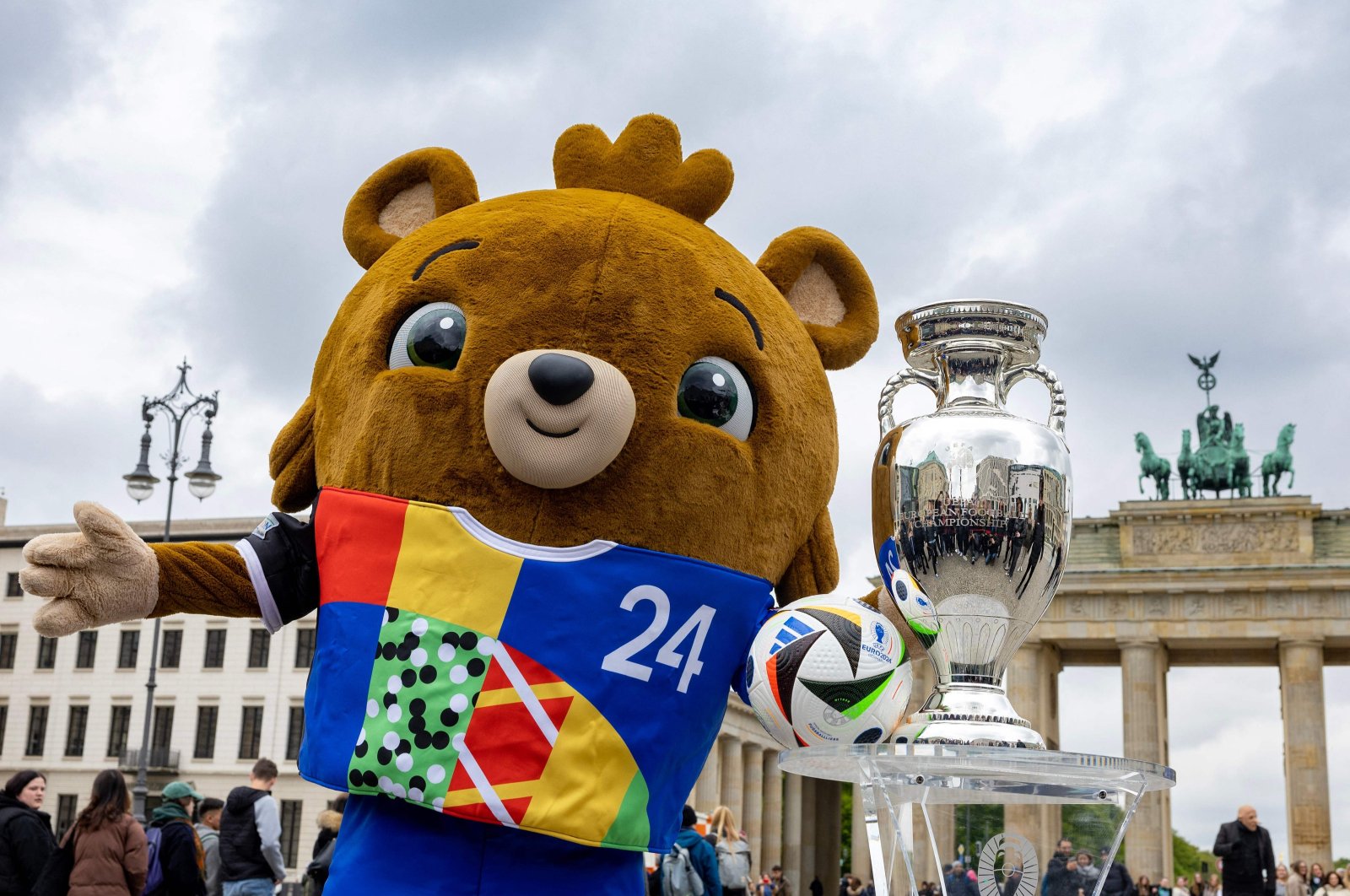 Teddy bear Albaert, the mascot of Euro 2024, poses with the UEFA Euro 2024 trophy as it goes on public display in front of the Brandenburger Gate, Berlin, Germany, April 24, 2024. (AFP Photo)