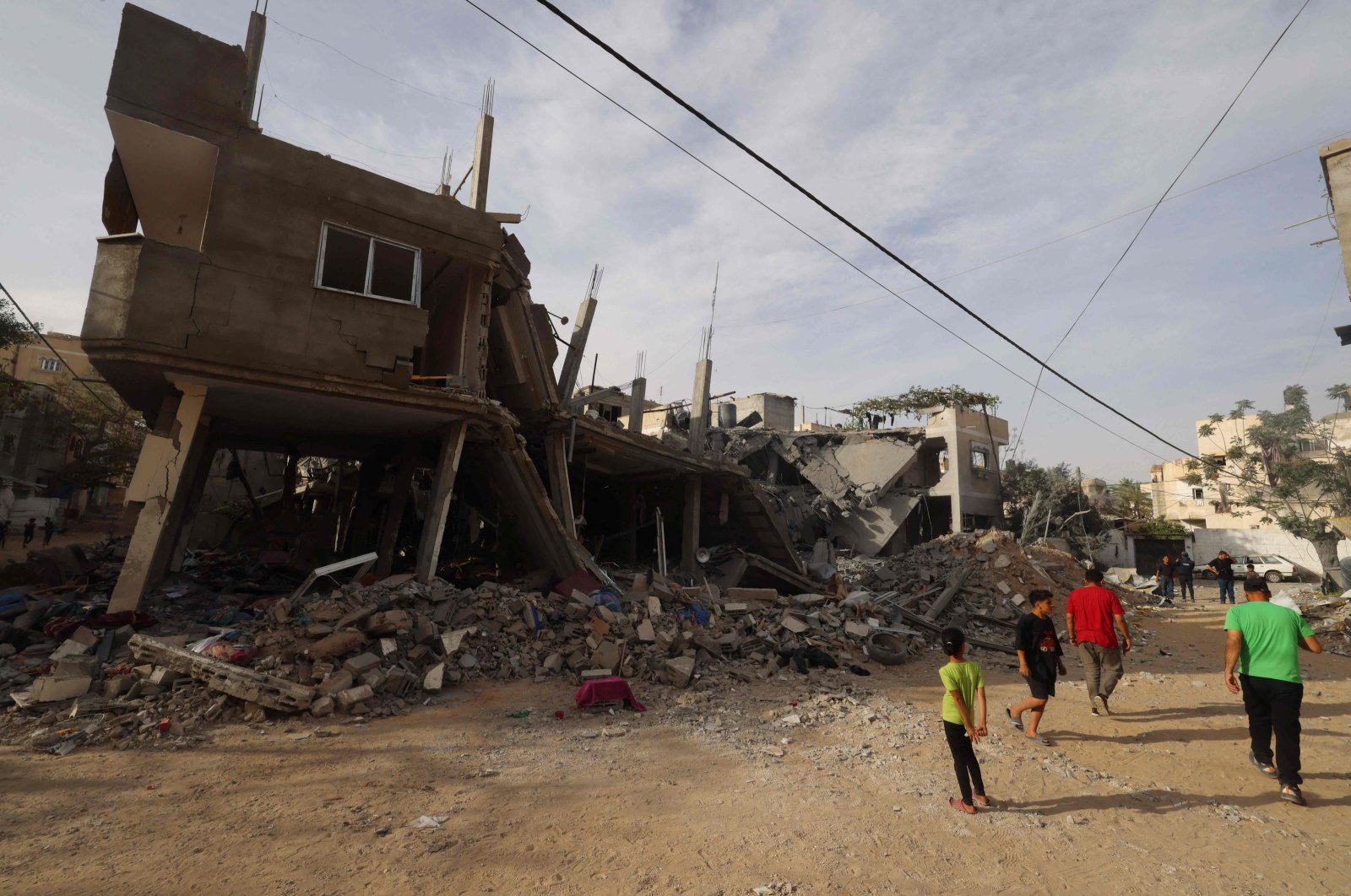 Palestinians walk past the rubble of a building destroyed in overnight Israeli bombardment in Rafah, southern Gaza Strip, April 25, 2024. (AFP Photo)