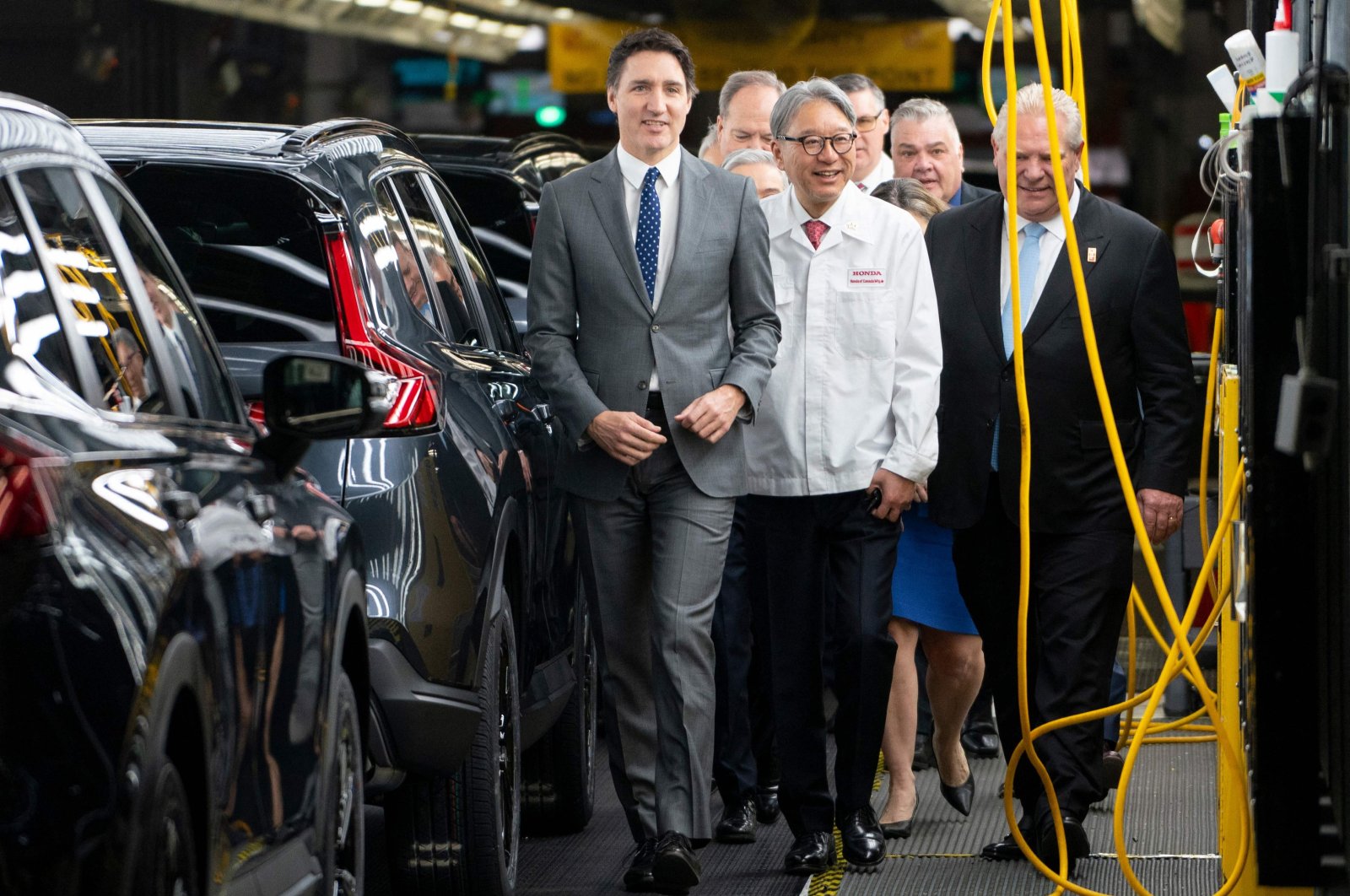 Canadian Prime Minister Justin Trudeau (Left), alongside Honda CEO Toshihiro Mibe (Center), and Ontario Premier Doug Ford (Right) tours the manufacturing line prior to an event at the Honda of Canada Manufacturing Plant 2 in Alliston, Ontario, Canada, April 25, 2024. (AFP Photo)
