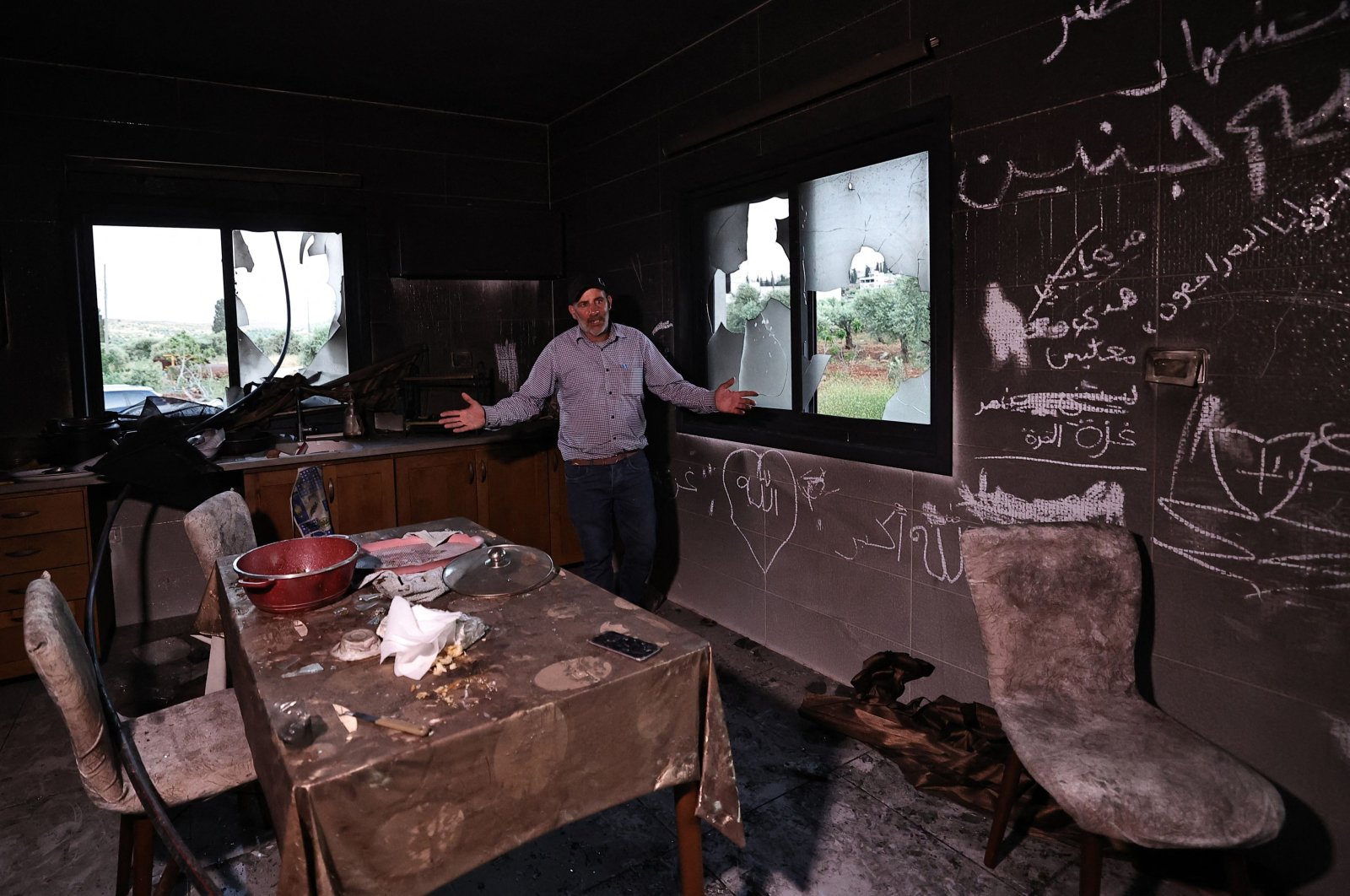 A Palestinian man gestures as he stands inside his kitchen in the aftermath of an attack by Israeli settlers in the occupied West Bank village of  Al-Mughayyir near Ramallah, Palestine, April 17, 2024. (AFP Photo)