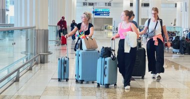 People walk with their luggage after a rainstorm hit Dubai, causing delays at Dubai International Airport, United Arab Emirates (UAE), April 17, 2024. (Reuters Photo)