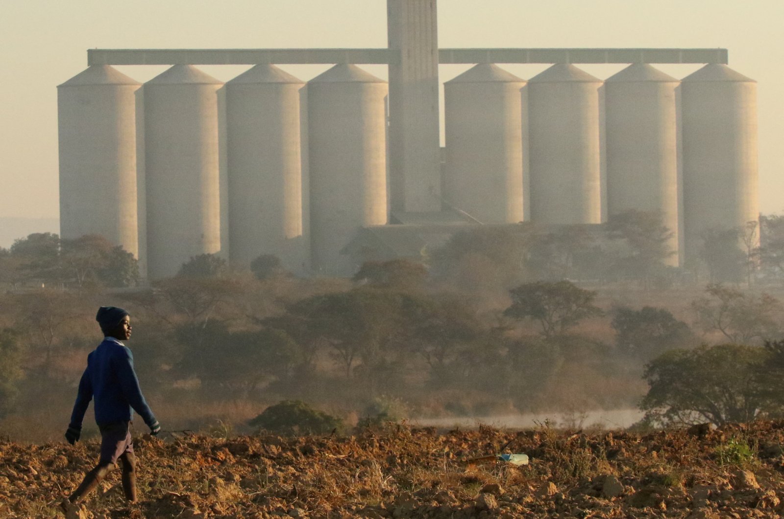 A boy walks along a prepared field in front of grain silos in the farming area of Chinhoyi, Zimbabwe, July 26, 2017. (Reuters Photo)