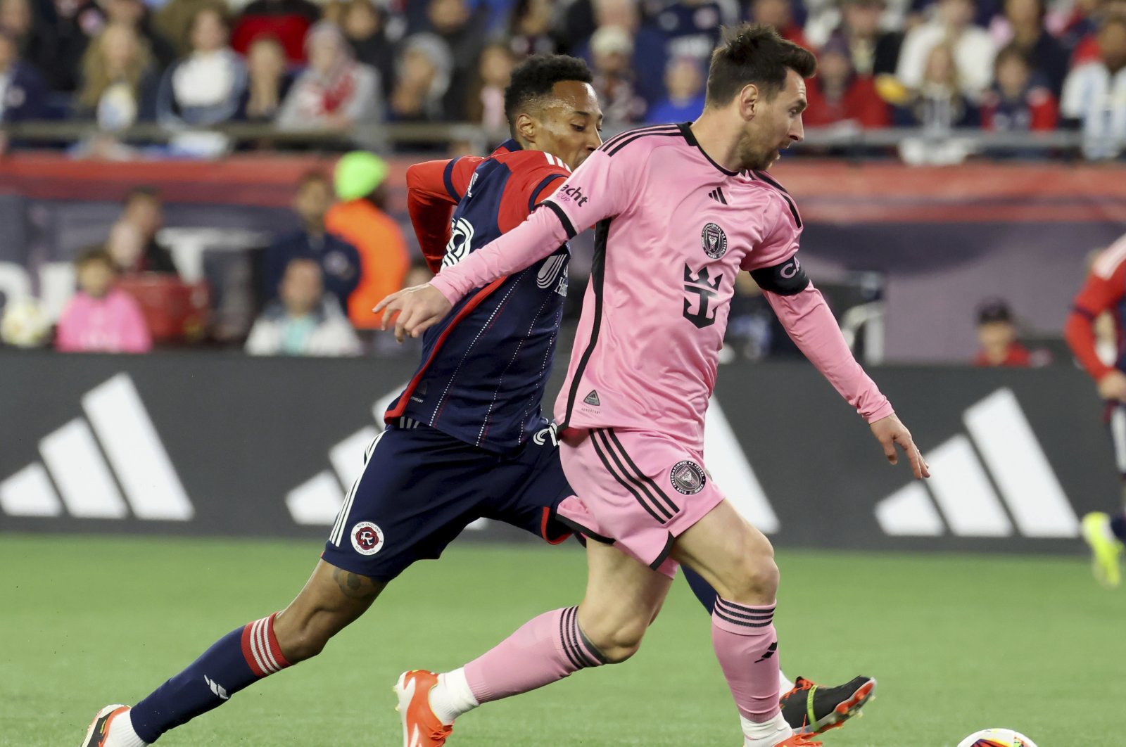 New England Revolution midfielder Mark-Anthony Kaye (L) and Inter Miami forward Lionel Messi chase the ball in the first half of an MLS match, Foxborough, U.S., April 27, 2024. (AP Photo)