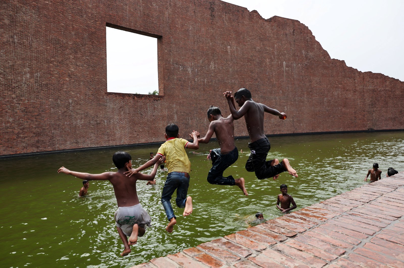 Children jump into the water body of Martyred Intellectuals Memorial to cool themselves during a heatwave in Dhaka, Bangladesh, April 23, 2024. (Reuters Photo)