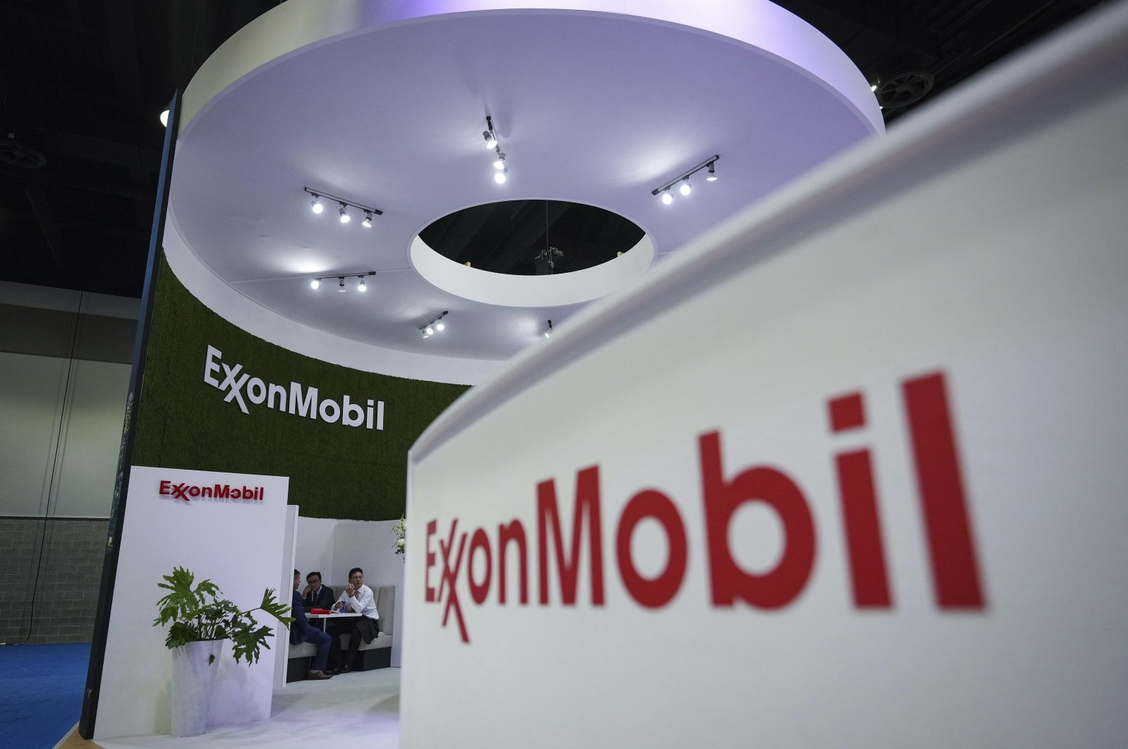 Delegates meet at the Exxon Mobil booth during the LNG2023 conference, Vancouver, British Columbia, Canada, July 11, 2023. (AP Photo)
