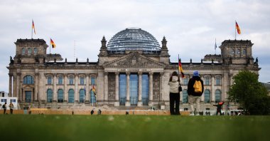 Passers-by stand on the meadow in front of the Reichstag building, the seat of the German parliament Bundestag, in Berlin, Germany, April 23, 2024. (EPA Photo)