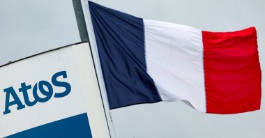 A French national flag flies near a logo of French IT consulting firm Atos, at the entrance of a company&#039;s building, Angers, France, March 20, 2024. (Reuters Photo)