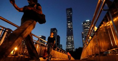Pedestrians walk on an overpass near skyscrapers at the Central Business District (CBD) in Beijing, China, Aug. 21, 2023. (Reuters Photo)