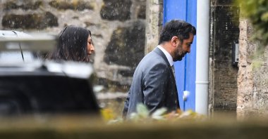 Scotland&#039;s First Minister Humza Yousaf (R), followed by his wife Nadia el-Nakla, arrives at Bute House ahead of a press conference, in Edinburgh, April 29, 2024. (AFP Photo)