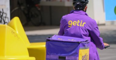 A courier of fast delivery company Getir rides to deliver an online grocery delivery, Dusseldorf, Germany, July 8, 2023. (Reuters Photo)