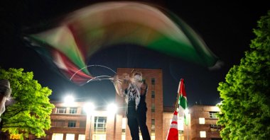 A protester waves a Palestinian flag at an encampment at University Yard at George Washington University in Washington, D.C., U.S., April 29, 2024. (AFP Photo)