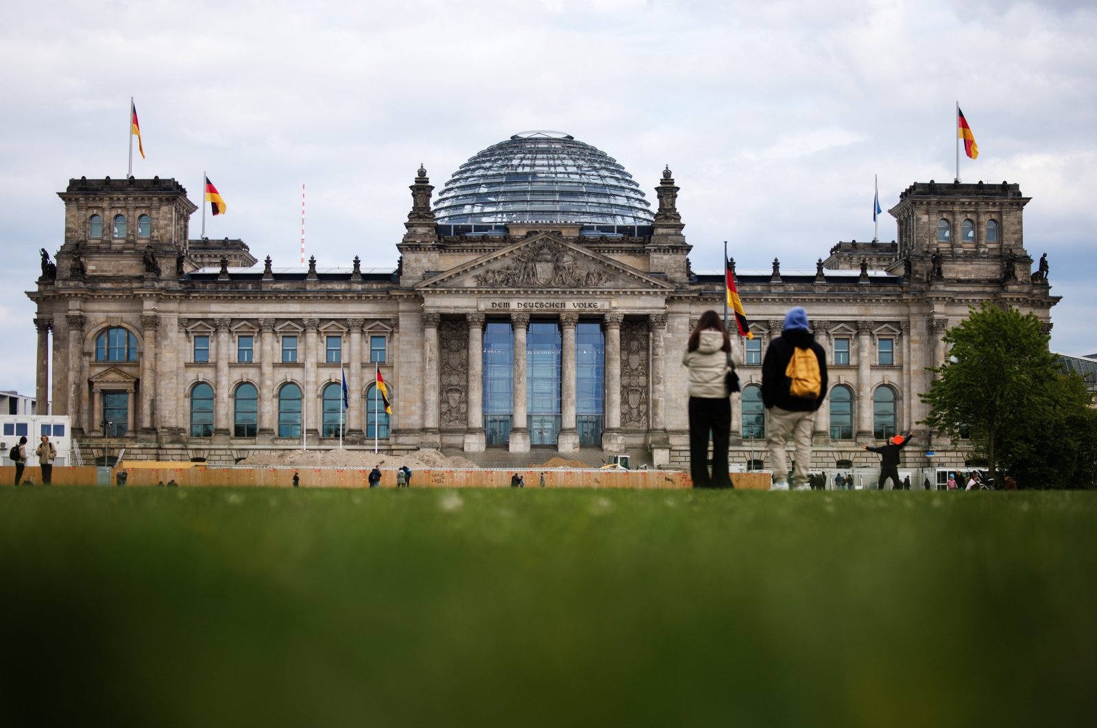 Passers-by stand on the meadow in front of the Reichstag building, the seat of the German parliament Bundestag, in Berlin, Germany, April 23, 2024. (EPA Photo)