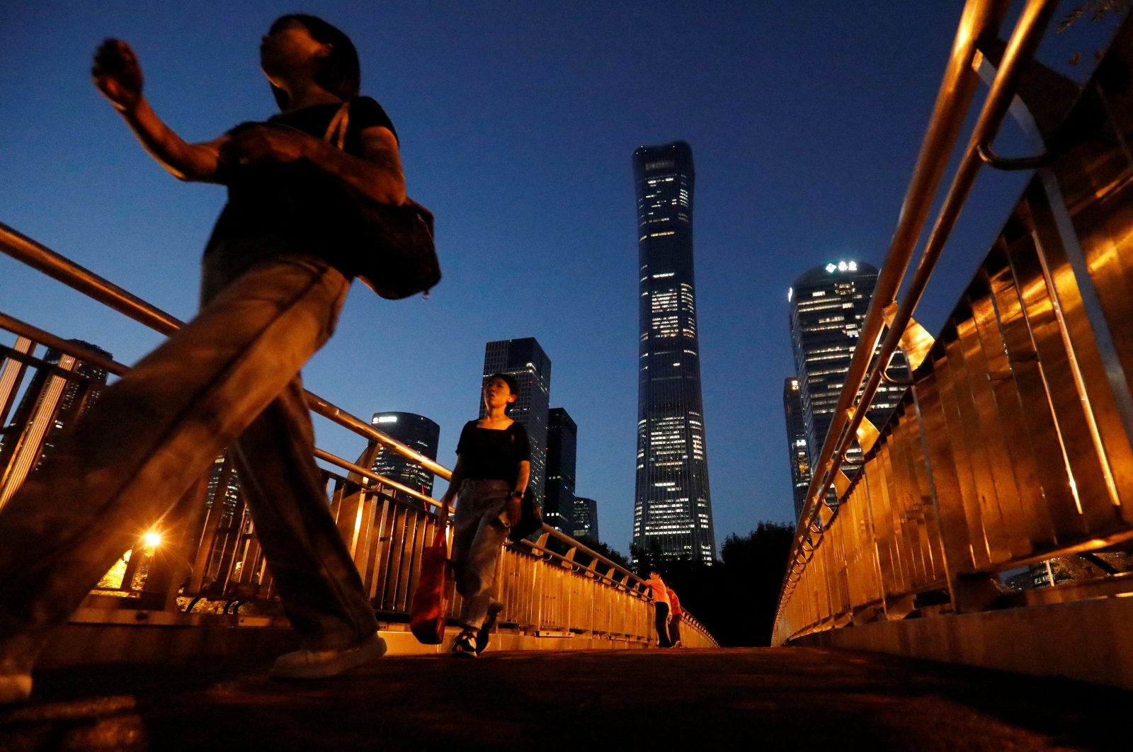 Pedestrians walk on an overpass near skyscrapers at the Central Business District (CBD) in Beijing, China, Aug. 21, 2023. (Reuters Photo)
