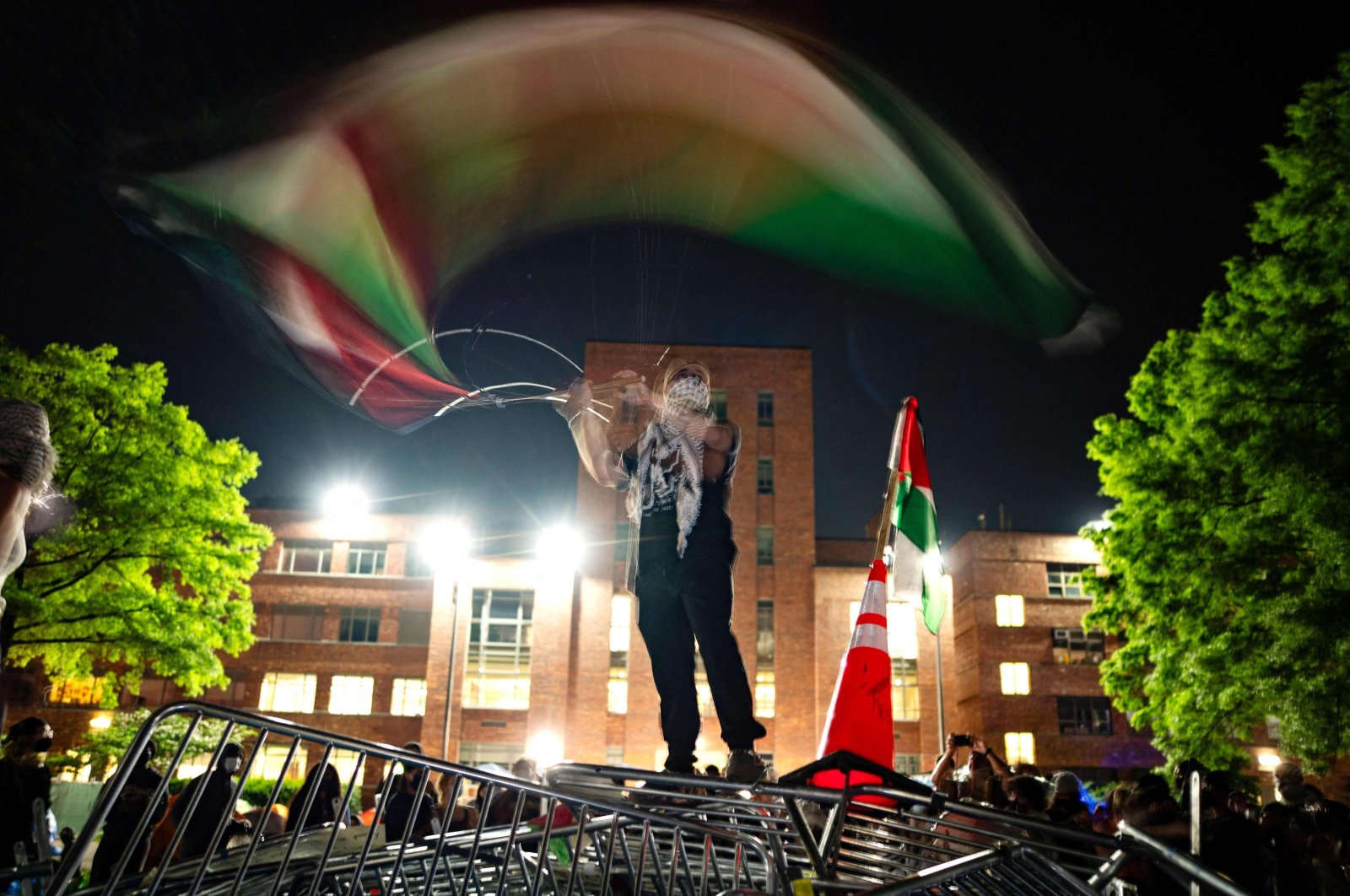 A protester waves a Palestinian flag at an encampment at University Yard at George Washington University in Washington, D.C., U.S., April 29, 2024. (AFP Photo)