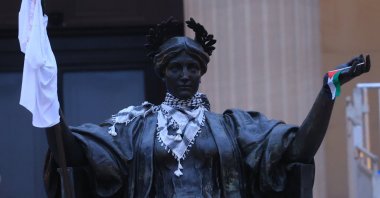 A stature in front of Columbia University&#039;s Hamilton Hall carry the keffiyeh and the Palestinian flag during protests, in New York, U.S., April 30, 2024. (AA Photo)