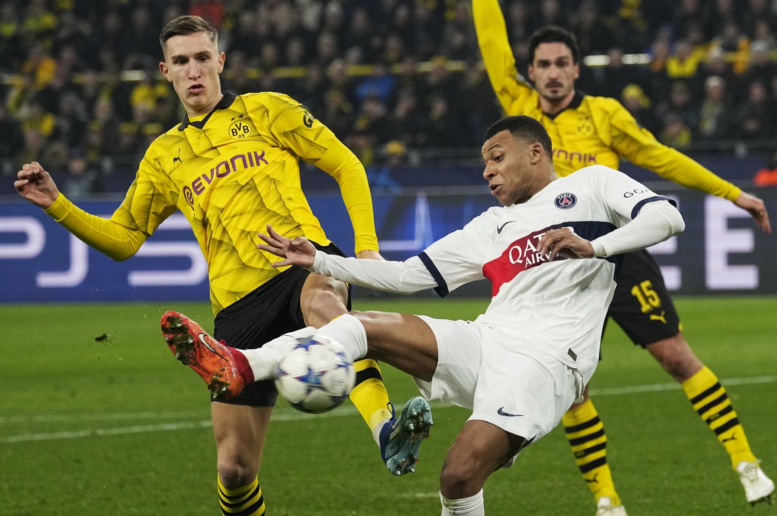 PSG&#039;s Kylian Mbappe (C) and Dortmund&#039;s Nico Schlotterbeck challenge for the ball during the Champions League Group F  match at the Signal Iduna Park, Dortmund, Germany, Dec. 13, 2023. (AP Photo)