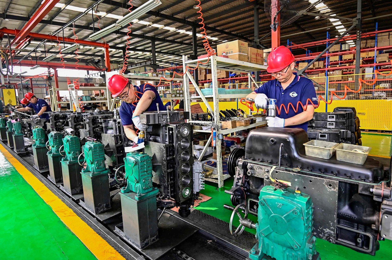 Employees work on an engine assembly line at an engine manufacturing factory in Qingzhou, eastern Shandong province, China, April 16, 2024. (AFP Photo)