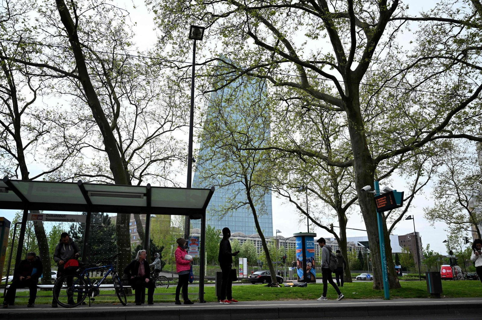 People wait at a bus stop close to the headquarters of the European Central Bank (ECB) in Frankfurt am Main, western Germany, April 11, 2024. (AFP Photo)