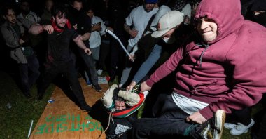 A pro-Palestinian demonstrator (C) is beaten by counterprotesters attacking a pro-Palestinian encampment on University of California Los Angeles (UCLA) campus, in Los Angeles, U.S., May 1, 2024. (AFP Photo)