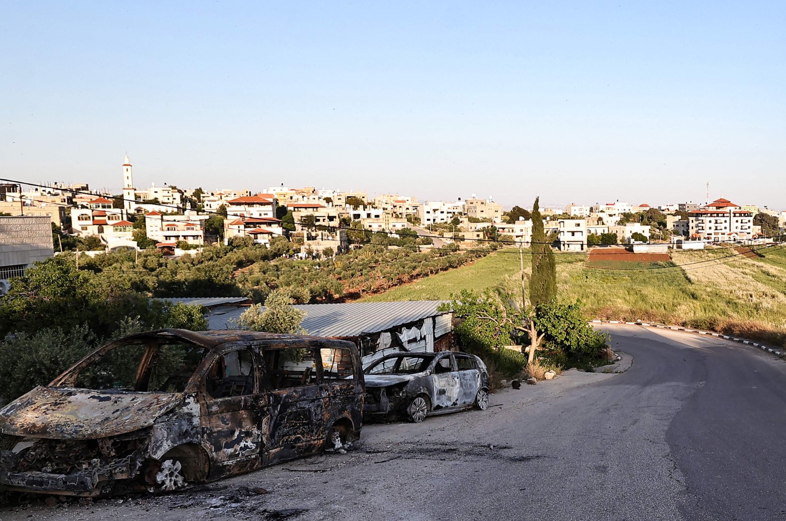 Charred cars sit at the entrance of the occupied West Bank village of Duma, in the aftermath of an Israeli settler attack, on April 17, 2024. (AFP Photo)