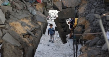 A Palestinian child stands in front of a building destroyed by Israeli bombing in Rafah in the southern Gaza Strip on May 3, 2024. (AFP Photo)