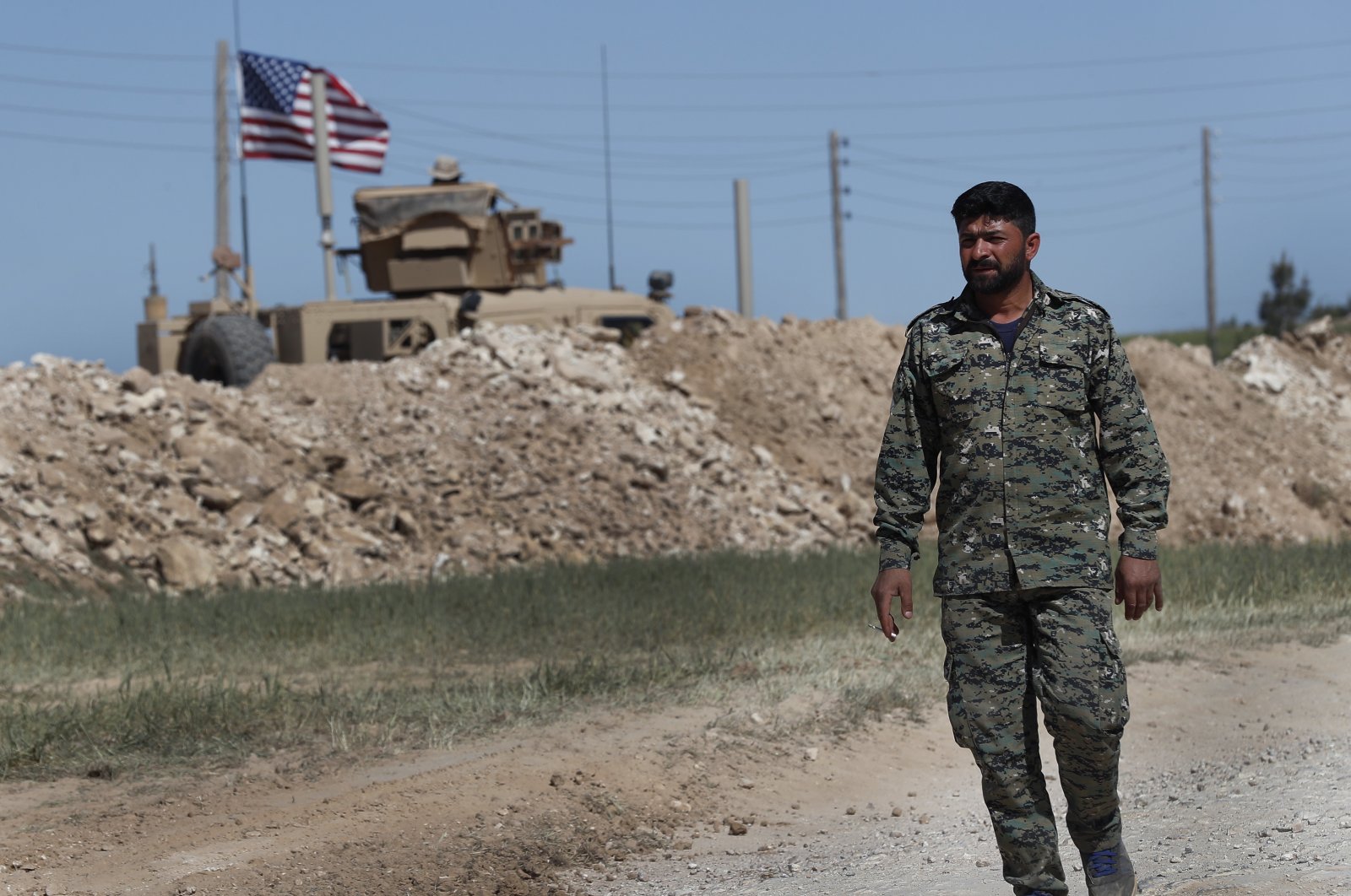 A YPG member passes a U.S. position in Manbij, Syria, on April 4, 2018. (AP Photo)