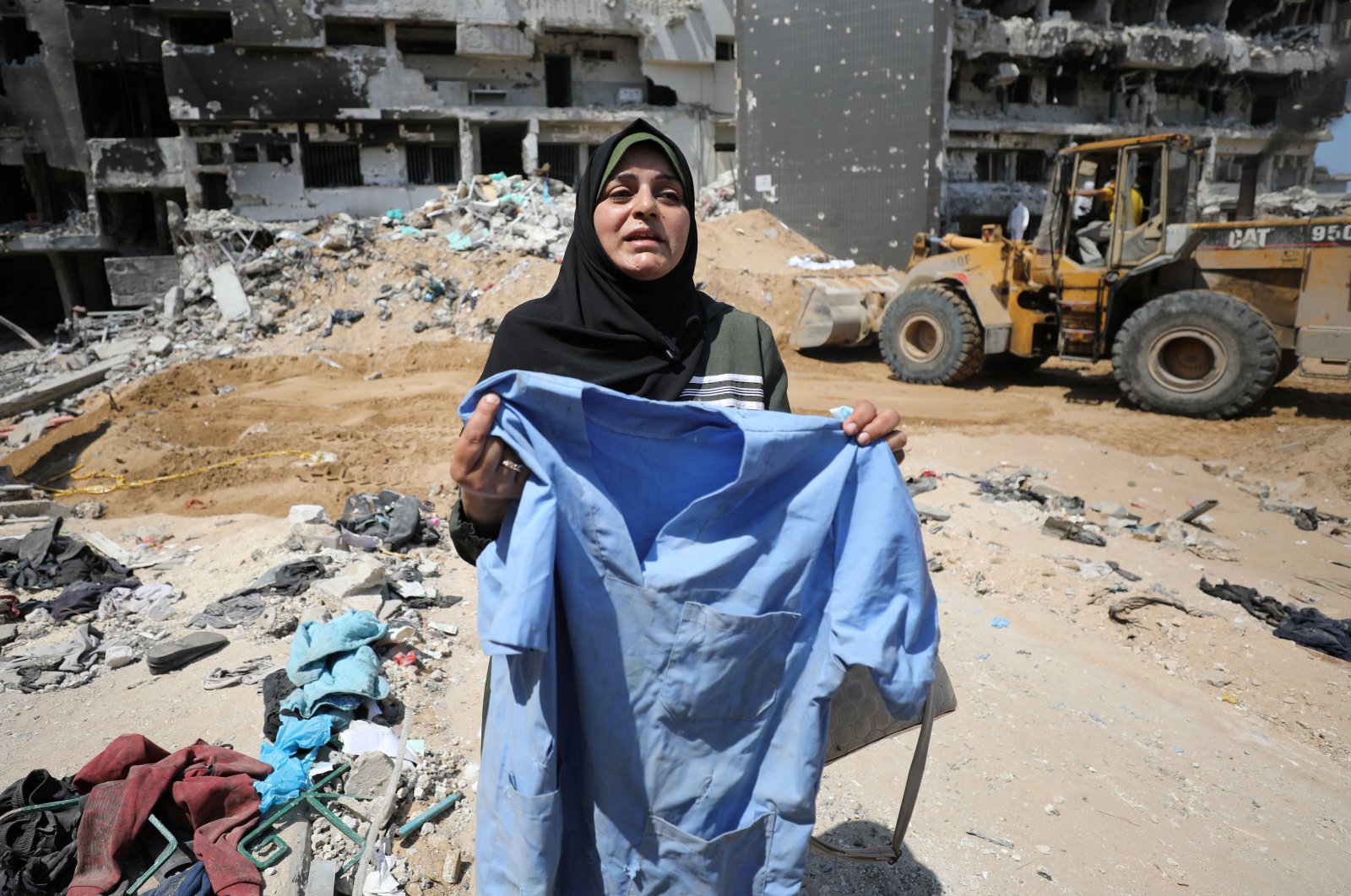 A woman holds clothing as rescuers and medics search for dead bodies inside the damaged Al Shifa Hospital after Israeli forces withdrew from the hospital and the area around it following a two-week operation, Gaza City, Palestine, April 8, 2024. (Reuters Photo)